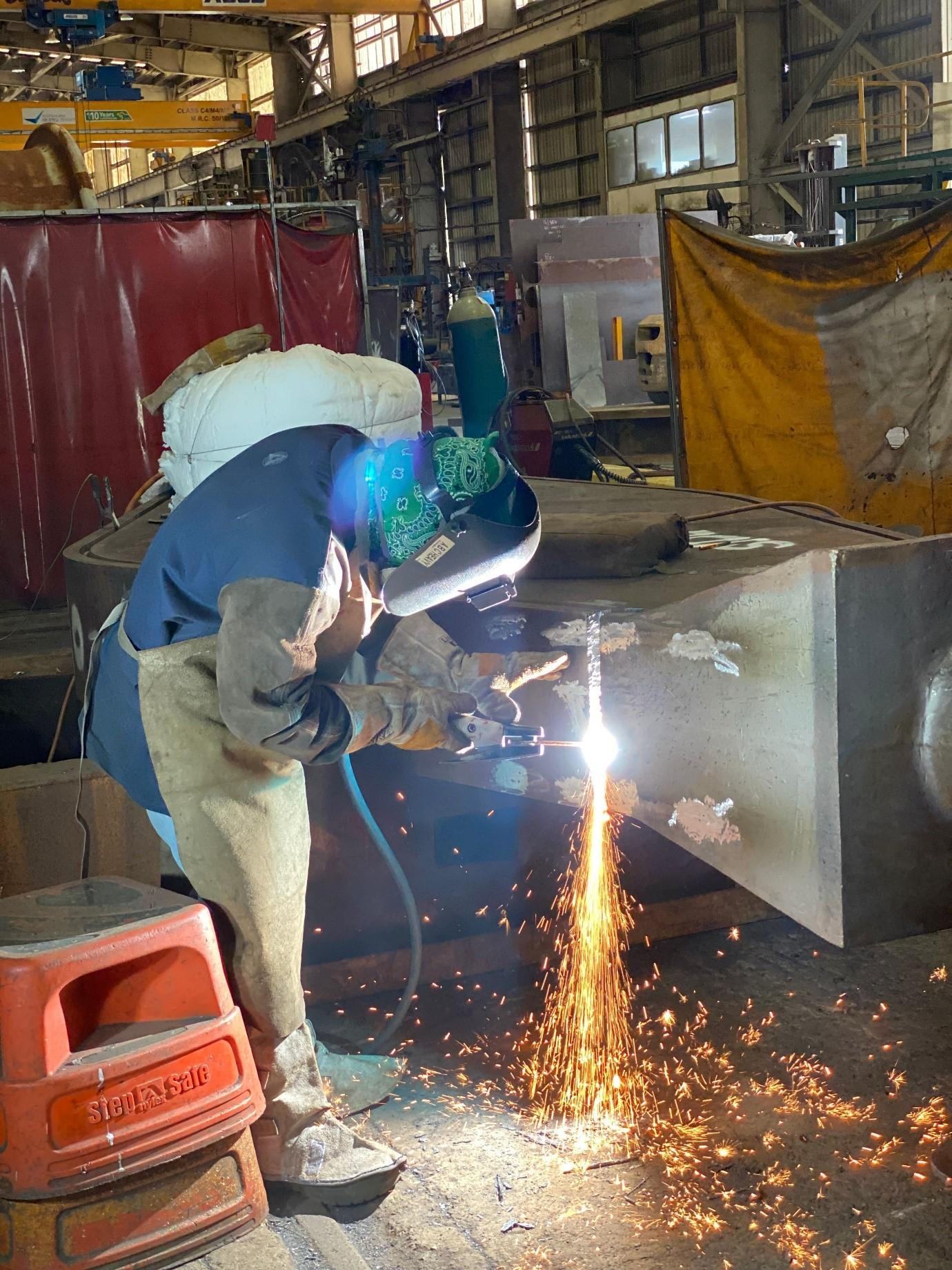 ABC welder working on a fabricated steel component in the Paget workshop