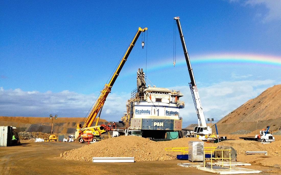 Two mobile cranes rigged over a Peabody P and H face shovel during a field rebuild, rainbow behind