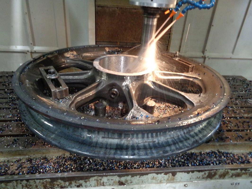 CNC machine cutting the hub of a dragline sheave wheel, sparks flying