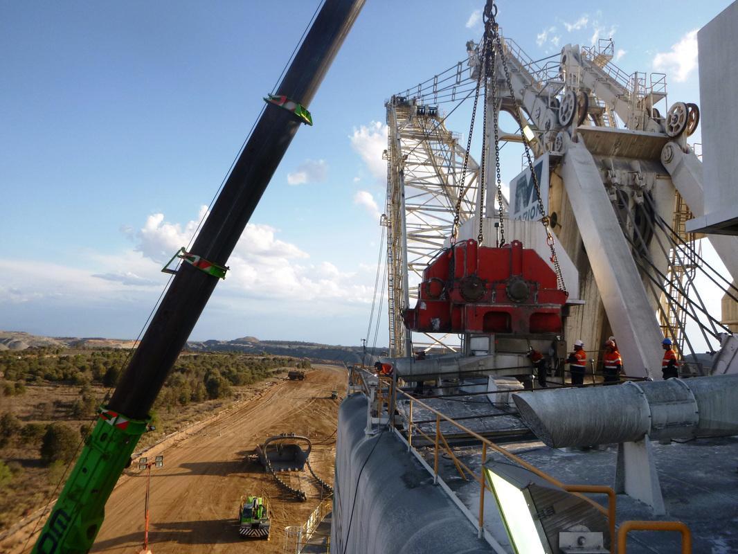 Crane hoisting a red propel gear case over a Marion 8750 dragline at an open-cut mine, ABC crew in hi-vis on the walking platform